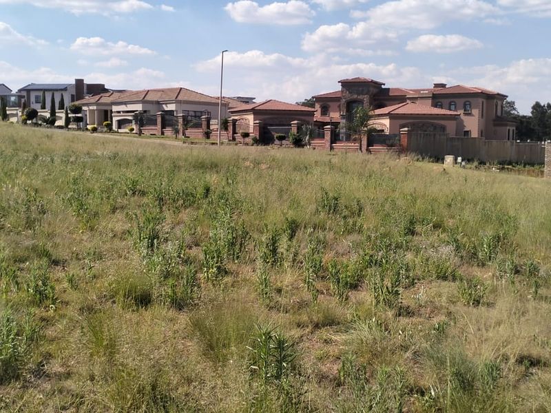 A view of a vacant residential plot of land situated within an established neighborhood with surrounding houses.