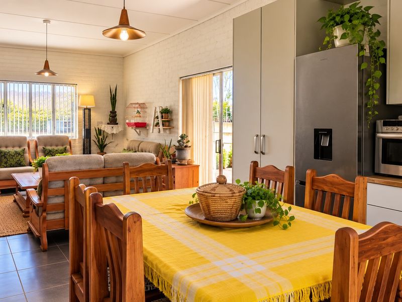 Spacious open-plan living and dining area featuring tiled floors, modern cabinetry, and direct access to the outdoor space through a sliding glass door.