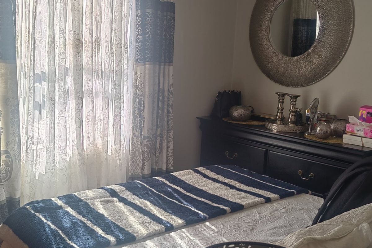 A cozy bedroom featuring natural light through window treatments, providing a comfortable and functional sleeping space.