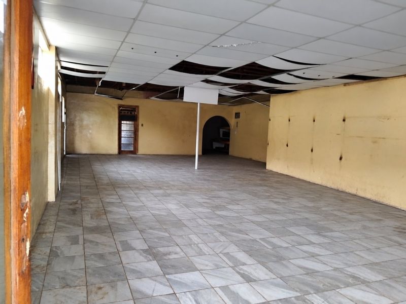 A vacant open-plan commercial space featuring tiled flooring and a damaged suspended ceiling, offering a blank canvas for renovation and interior fit-out.
