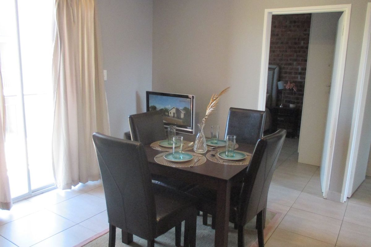 A dining area featuring tiled flooring and a sliding glass door providing natural light, with an open doorway leading to an adjacent room.