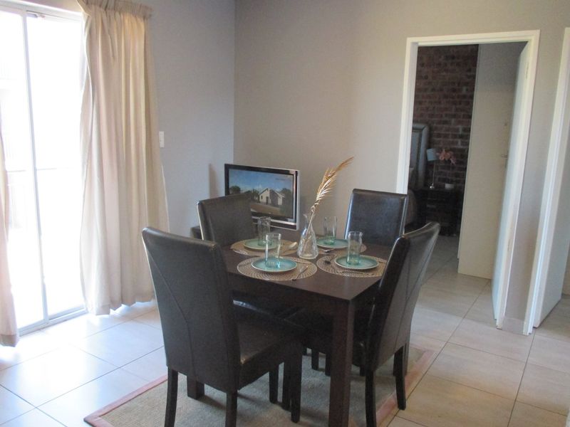 A dining area featuring tiled flooring and a sliding glass door providing natural light, with an open doorway leading to an adjacent room.