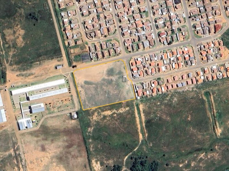 An aerial view of a vacant residential land plot highlighted in yellow, situated within an established suburban neighborhood.