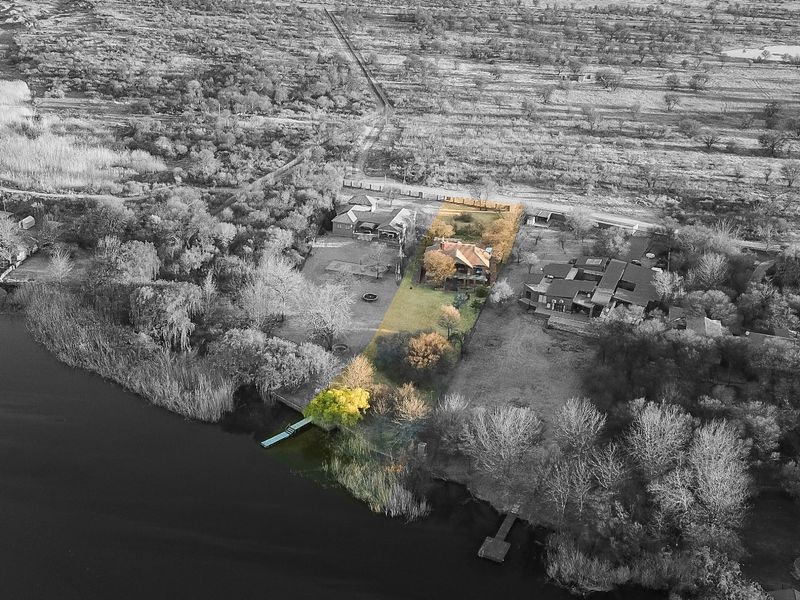 Aerial view of the property highlighting the expansive garden, waterfront access, and private jetty on the riverbank.