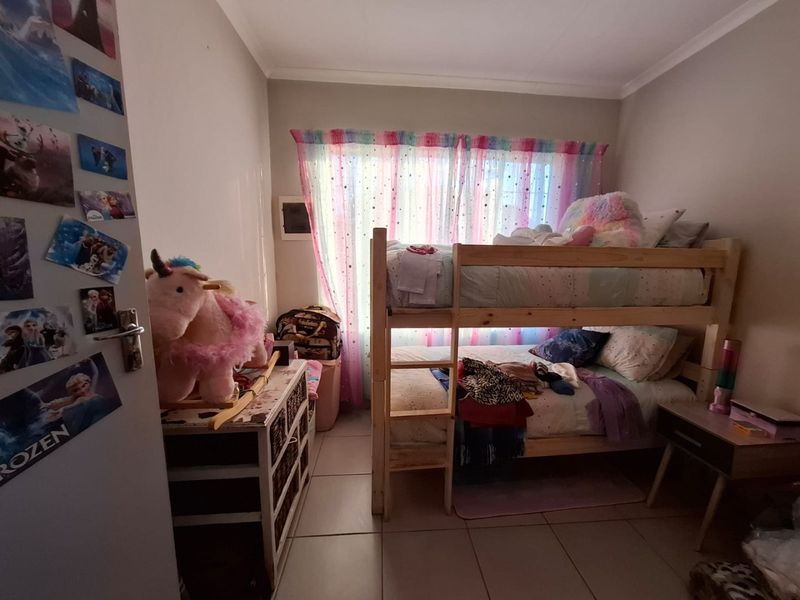 A functional bedroom featuring tiled flooring and coved ceiling details, providing a comfortable space for rest.