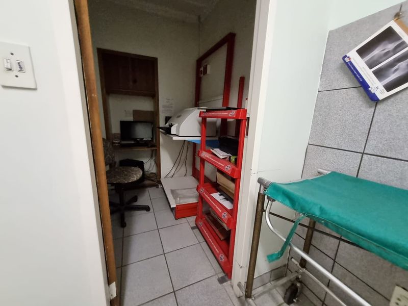 A small utility or storage area featuring tiled flooring and built-in shelving, suitable for administrative or medical equipment storage.