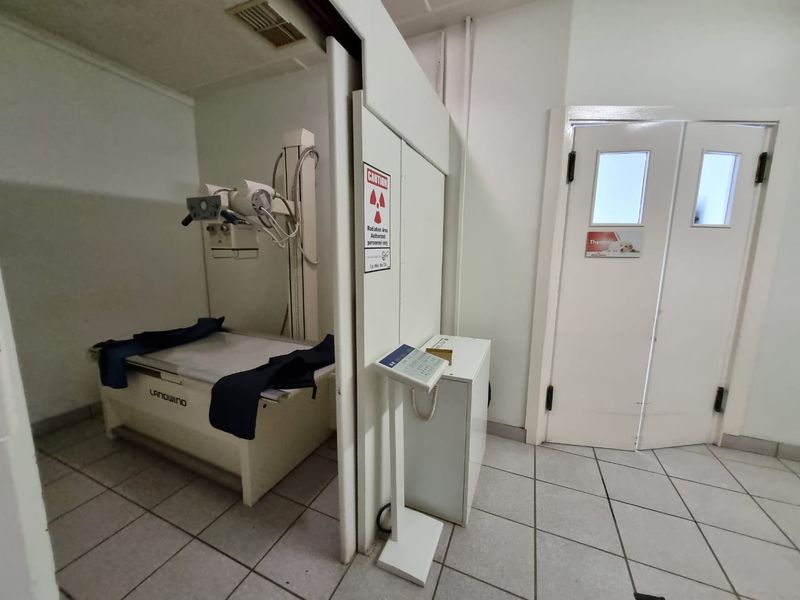 Specialized medical utility room featuring an integrated x-ray imaging station with radiation shielding and durable tiled flooring.