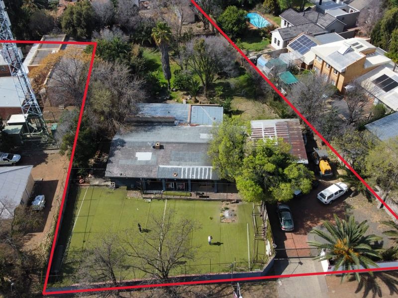 Aerial view of the property showing the main dwelling, large garden area with artificial turf, paved driveway, and an on-site telecommunications tower.