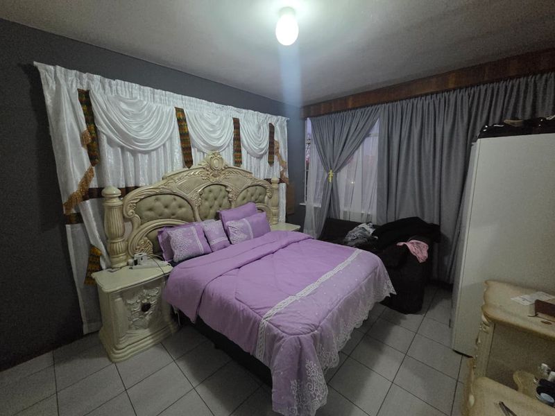 A bedroom featuring tiled flooring and neutral wall finishes, providing a functional space for rest.