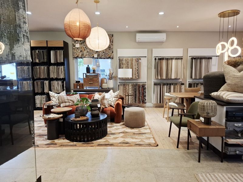 A well-maintained commercial showroom space featuring integrated fabric sample displays, recessed lighting, and a combination of stone and timber flooring.
