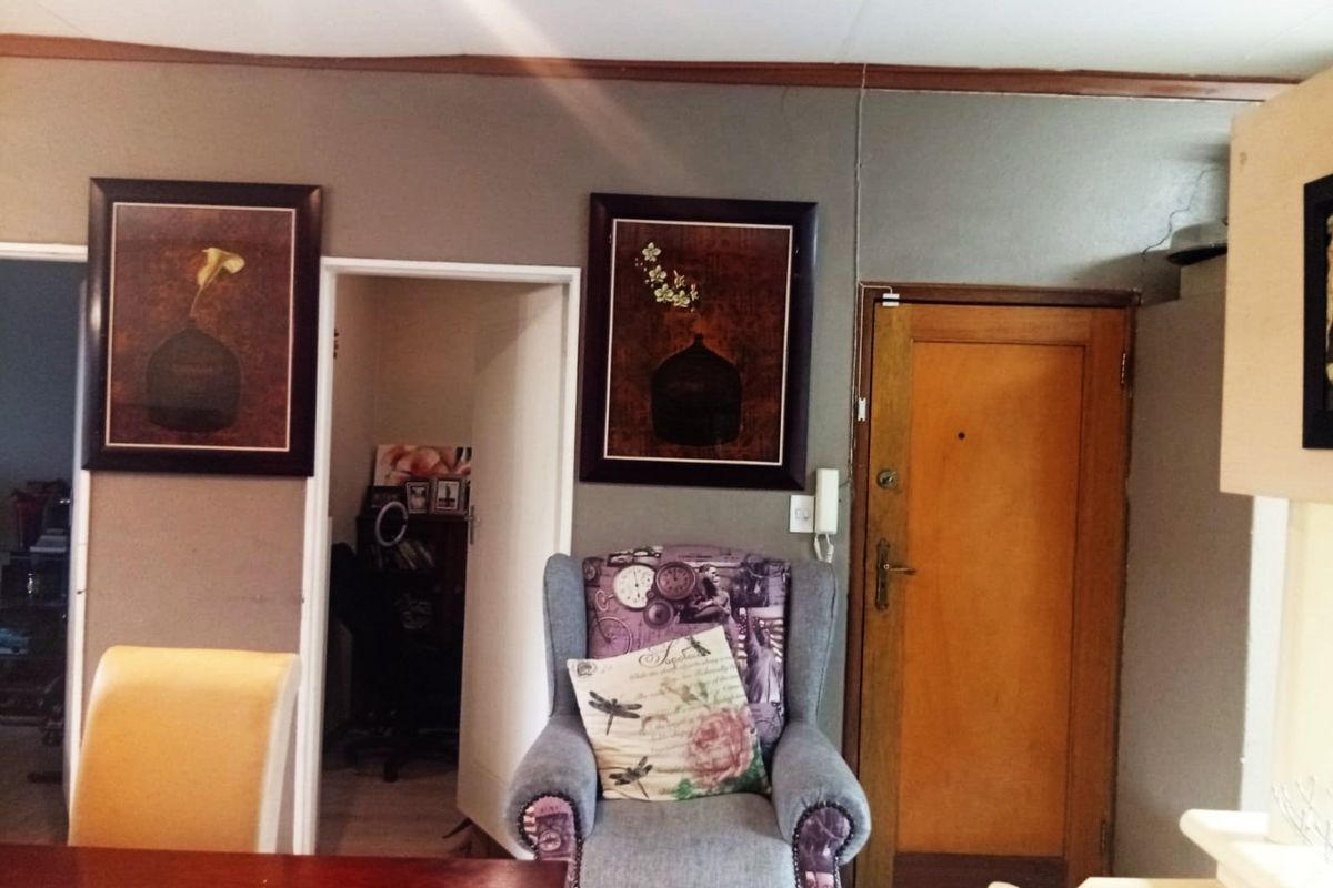 A living area featuring a timber entrance door and an integrated intercom system, providing access to adjacent rooms.