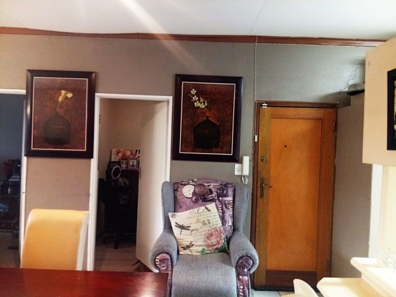 A living area featuring a timber entrance door and an integrated intercom system, providing access to adjacent rooms.