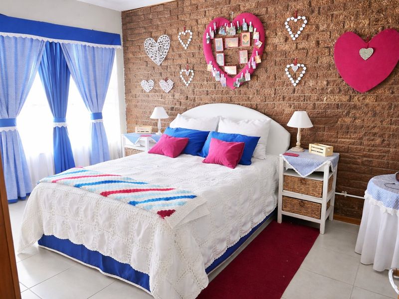 A bedroom featuring an exposed brick feature wall and tiled flooring, offering a distinct character and potential for modern updates.
