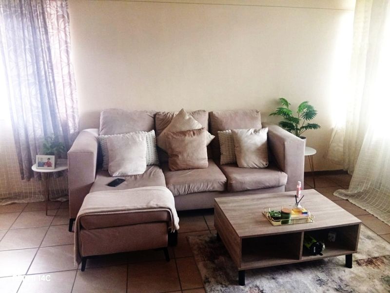 A living room area featuring tiled flooring and neutral wall finishes, providing a functional space for relaxation.