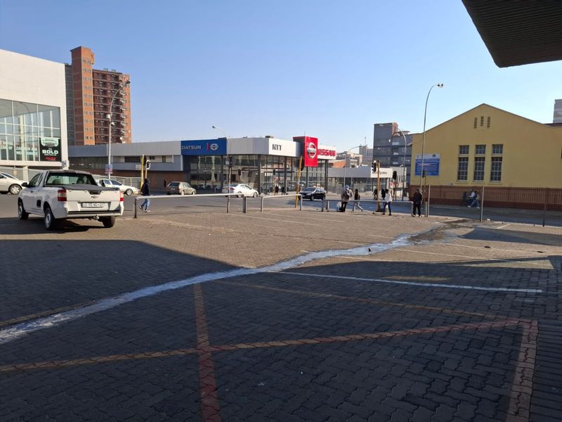 Exterior view of a commercial paved parking area and surrounding street infrastructure.