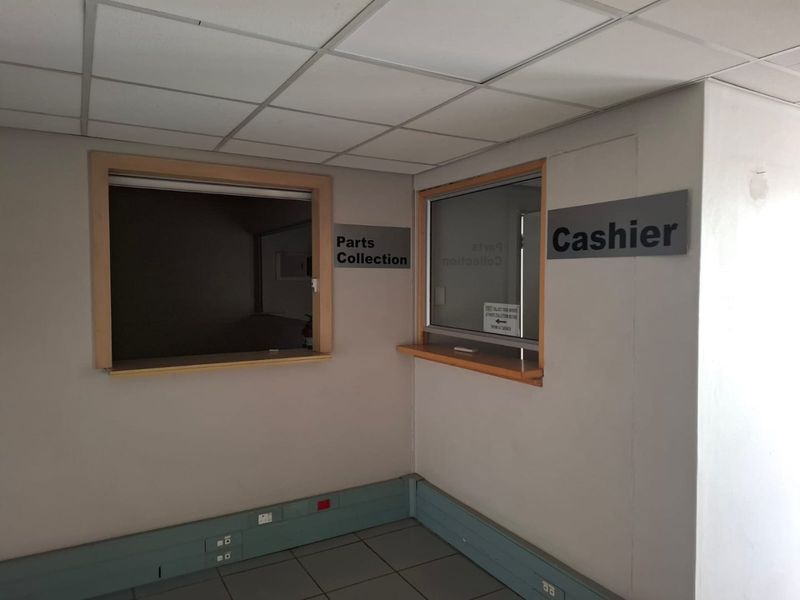Commercial service area featuring dedicated cashier and parts collection counters with tiled flooring and integrated electrical trunking.