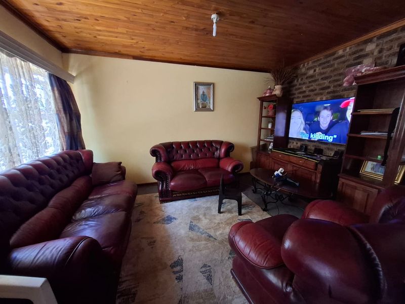 A living room featuring an exposed timber ceiling and a rustic exposed brick feature wall, providing a warm and traditional aesthetic.
