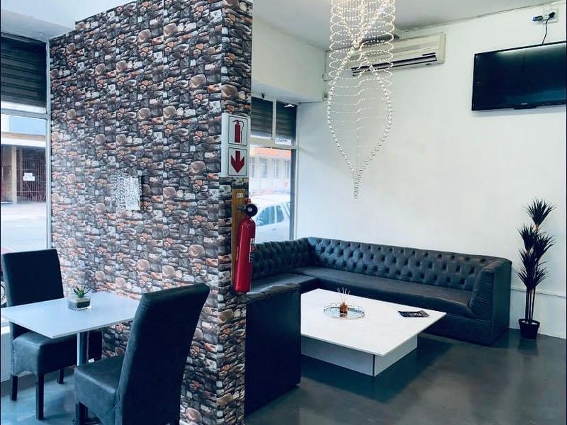 Commercial lounge area featuring a stone-effect feature wall, split-system air conditioning, and integrated safety equipment.