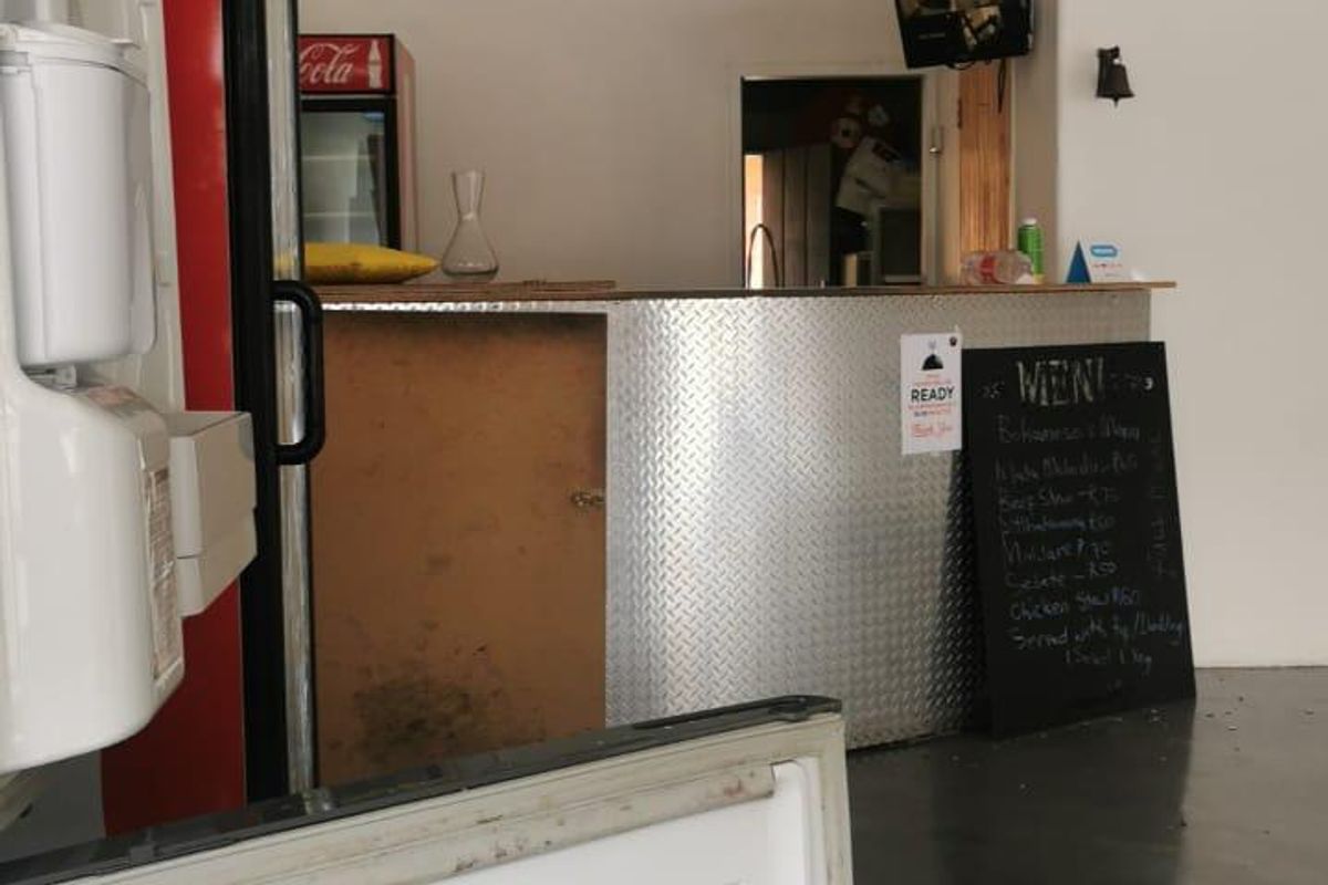Commercial kitchen service area featuring a metal-clad counter, basic lighting, and functional service space suitable for food preparation or retail operations.