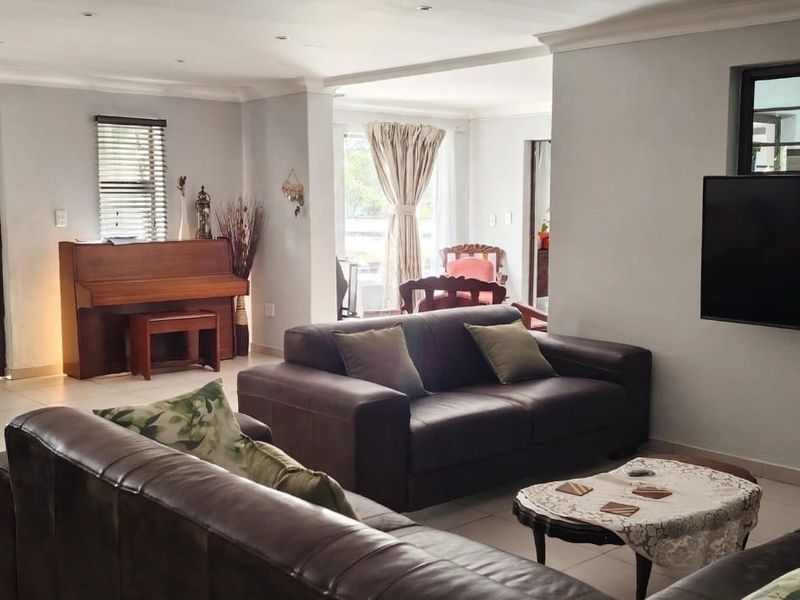 Spacious living room featuring tiled flooring, recessed ceiling lighting, and neutral wall finishes, providing a comfortable and well-lit area for relaxation.