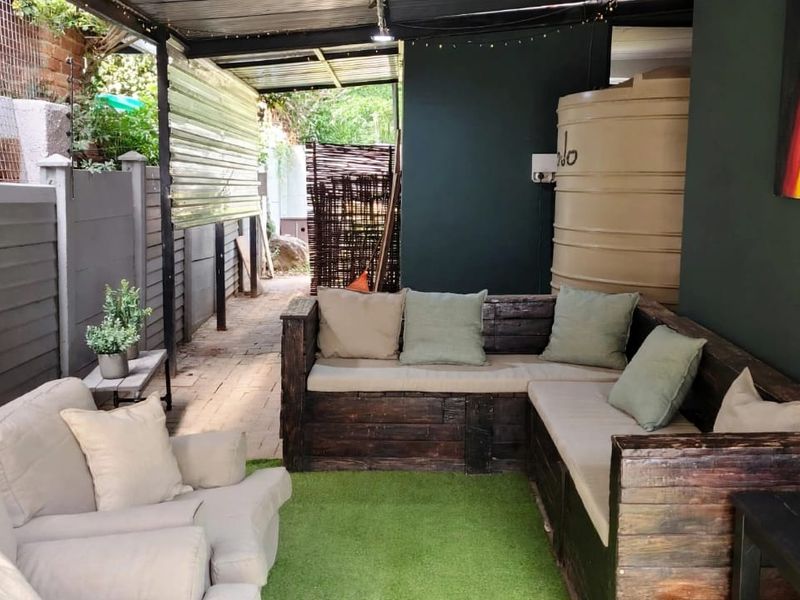 A covered outdoor patio area featuring paved flooring, a water storage tank, and perimeter fencing, providing a functional space for outdoor relaxation.