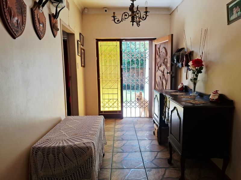 Entrance hall featuring tiled flooring, a decorative stained glass door, and a security gate leading to the exterior.