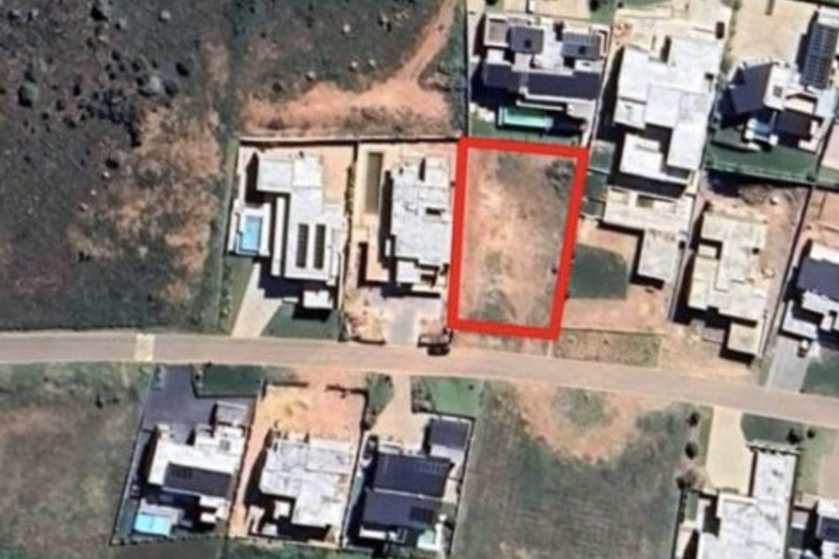 Aerial view of a vacant residential plot in a developed estate, showing the property boundaries and surrounding neighborhood context.