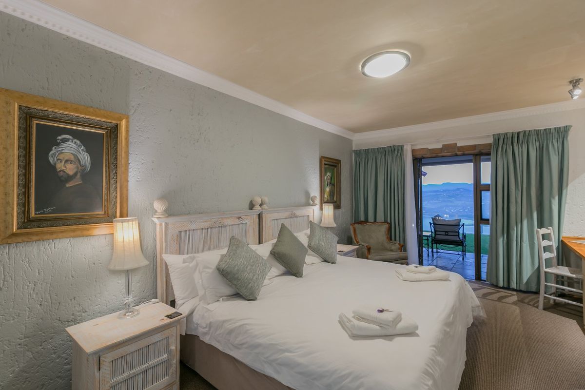 A well-maintained bedroom featuring textured walls, crown molding, and direct access to a private balcony with scenic views.
