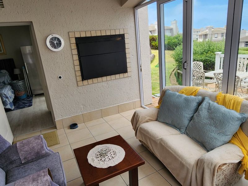 Enclosed patio area featuring tiled flooring, a built-in fireplace, and large aluminium sliding doors providing access to the outdoor space.