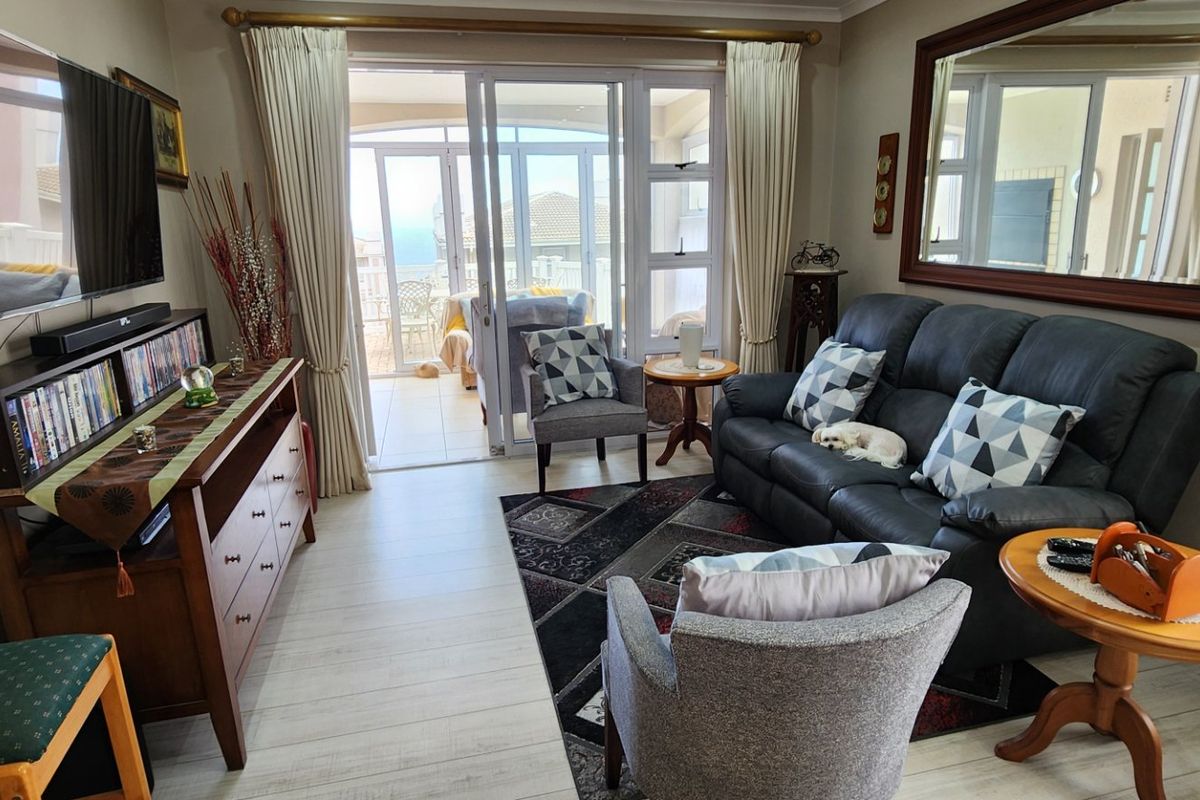 A comfortable living room featuring laminate flooring and large sliding glass doors that provide access to an adjoining patio area.