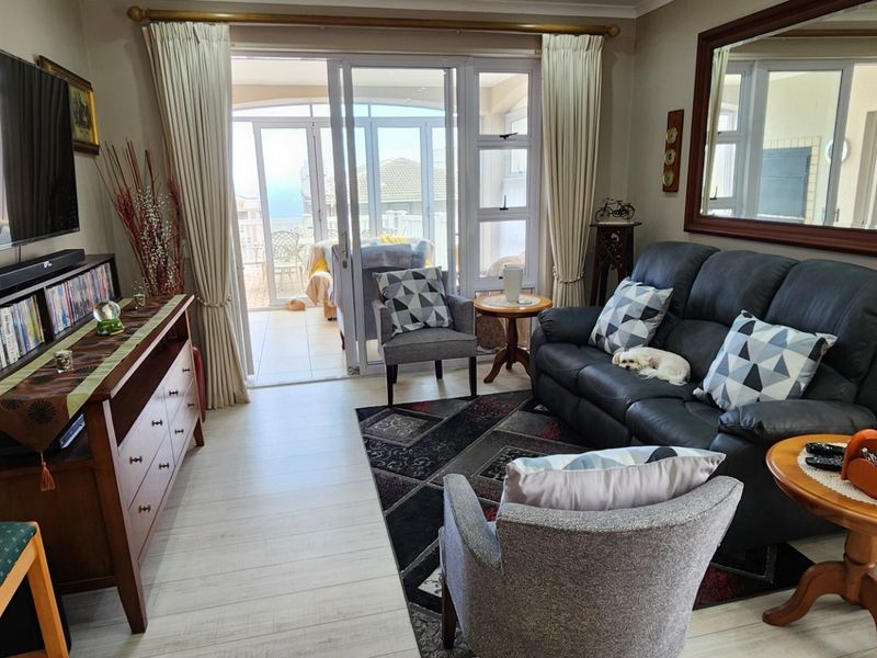 A comfortable living room featuring laminate flooring and large sliding glass doors that provide access to an adjoining patio area.