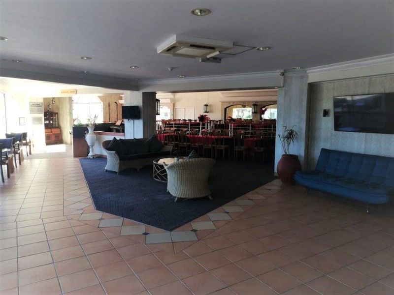 Spacious open-plan living and dining area featuring tiled flooring, recessed ceiling lighting, and a neutral interior layout suitable for various configurations.