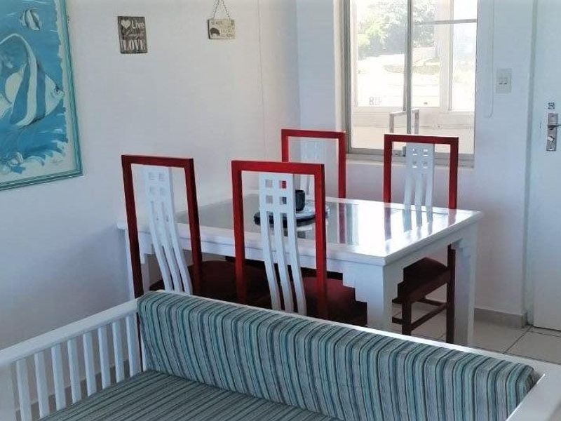 A bright dining area featuring tiled flooring and a window, providing a functional space for meals within the apartment.