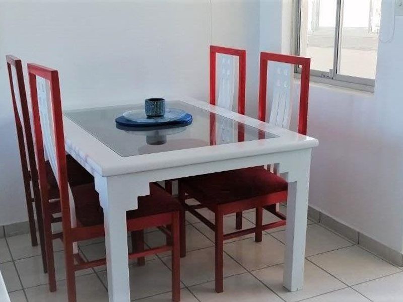 A dining area featuring tiled flooring and a window, providing a functional space for meals within the apartment.