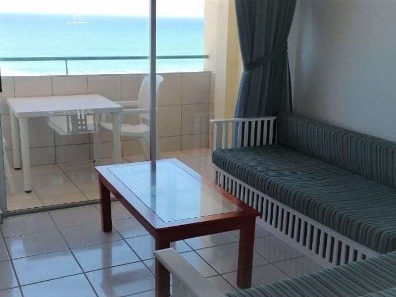 Living area with tiled flooring and large sliding glass doors opening onto a balcony with ocean views.