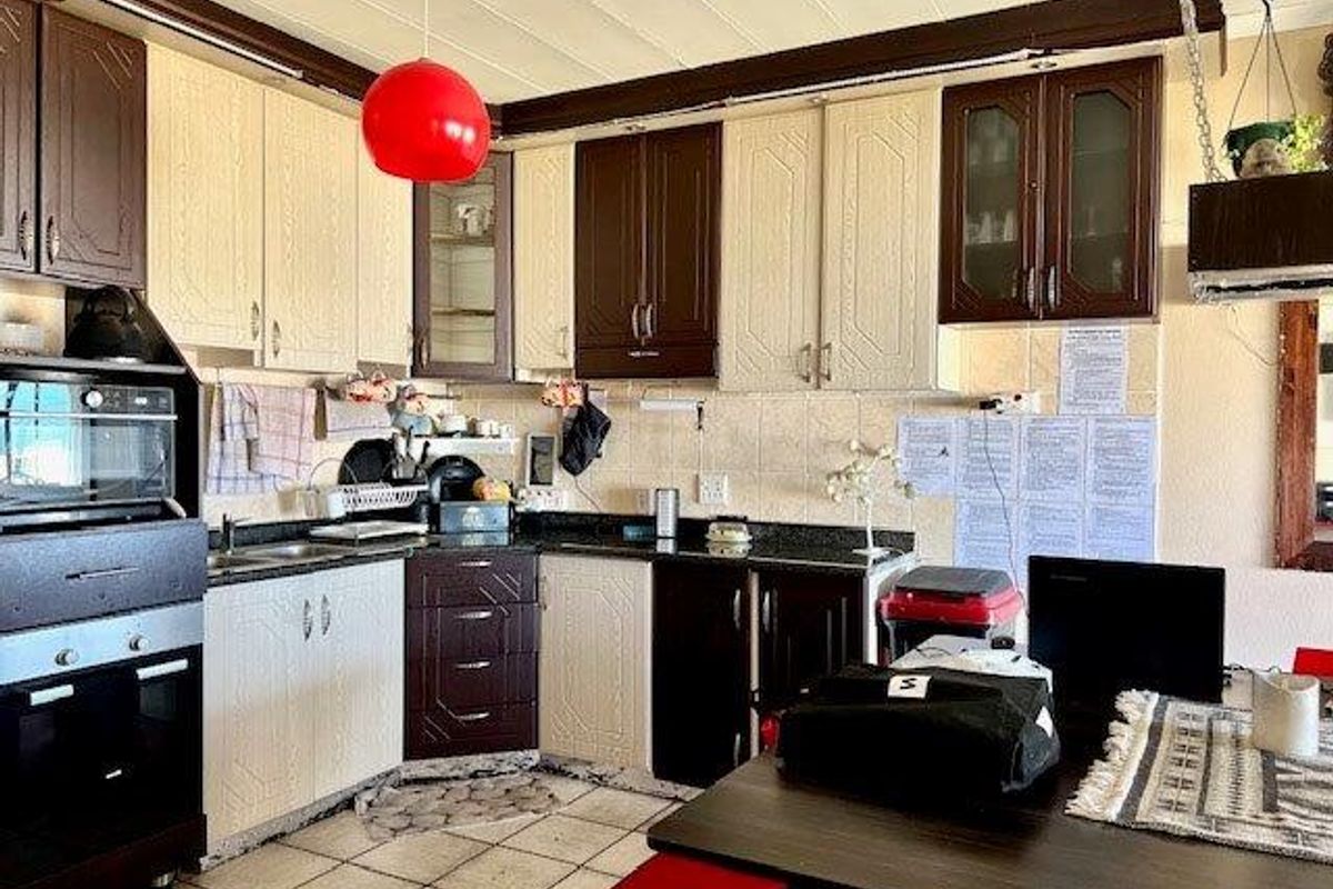 A functional kitchen featuring two-tone cabinetry, granite countertops, tiled backsplash, and built-in oven, offering a practical layout with ample storage space.