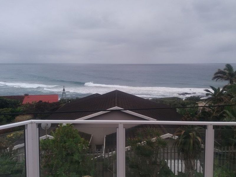 Elevated coastal view overlooking the ocean and surrounding residential properties from a balcony.