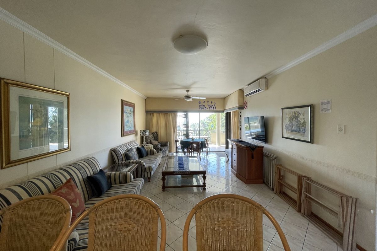 Spacious living area featuring ceramic tile flooring, a ceiling fan, and a split-system air conditioner, with direct access to an outdoor balcony.