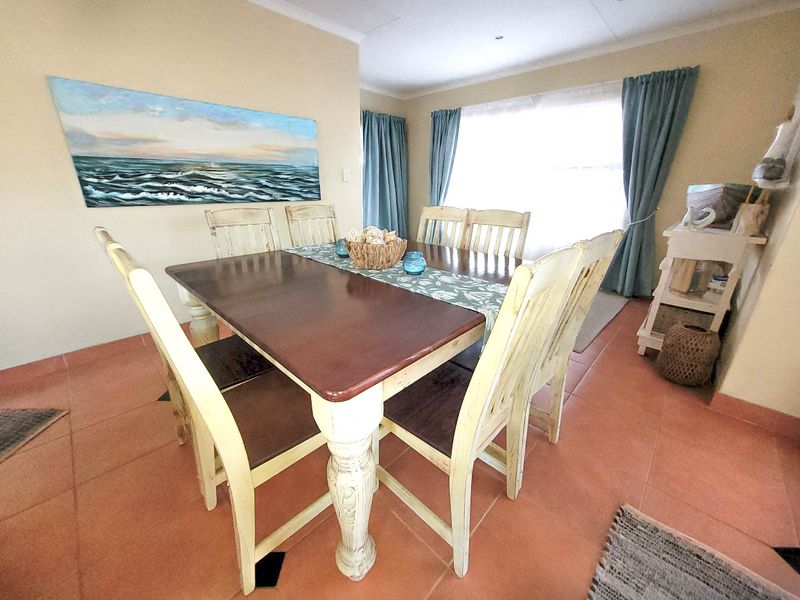 A functional dining room featuring tiled flooring and recessed lighting, providing a comfortable space for family meals and entertaining.