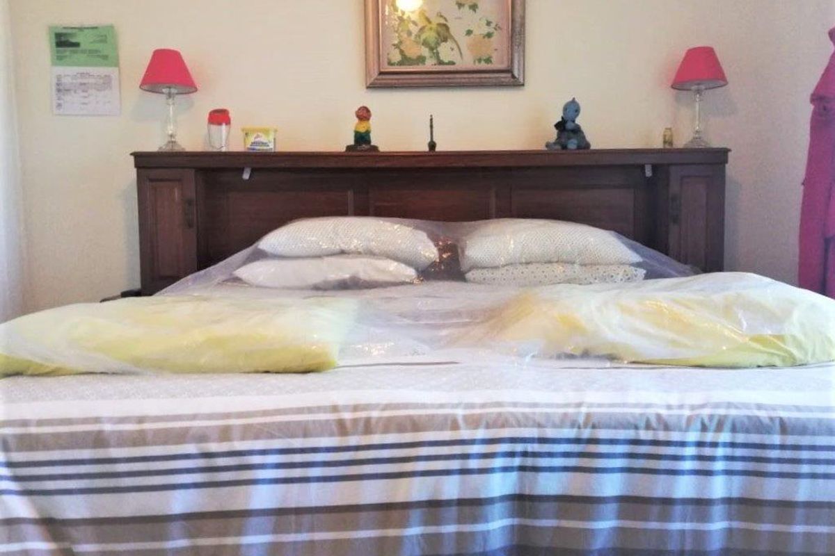 A bedroom featuring a built-in wooden headboard, providing a functional foundation for the sleeping area.