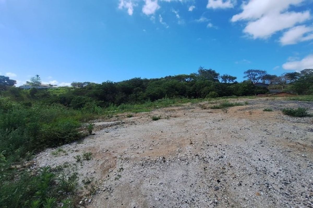 A view of a vacant residential plot featuring cleared land and a gravel surface, ready for development.