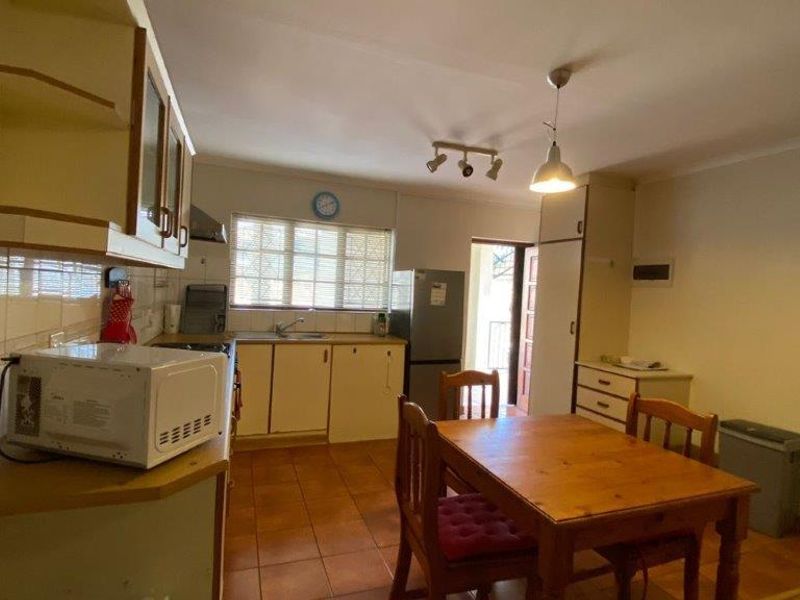 Open-plan kitchen and dining area featuring tiled flooring, built-in cabinetry, and a functional layout suitable for modern updates.