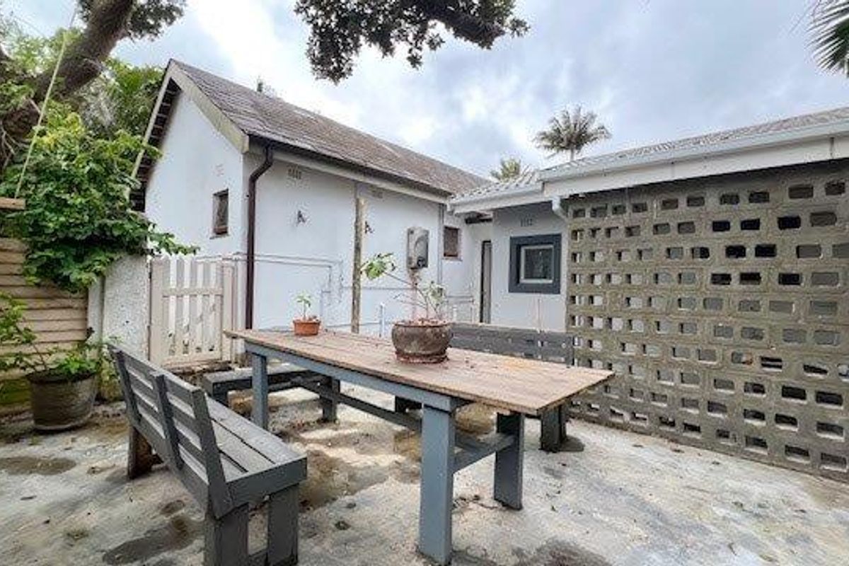 A rear courtyard area featuring a concrete patio, breeze block wall, and timber fencing, providing a functional outdoor space.
