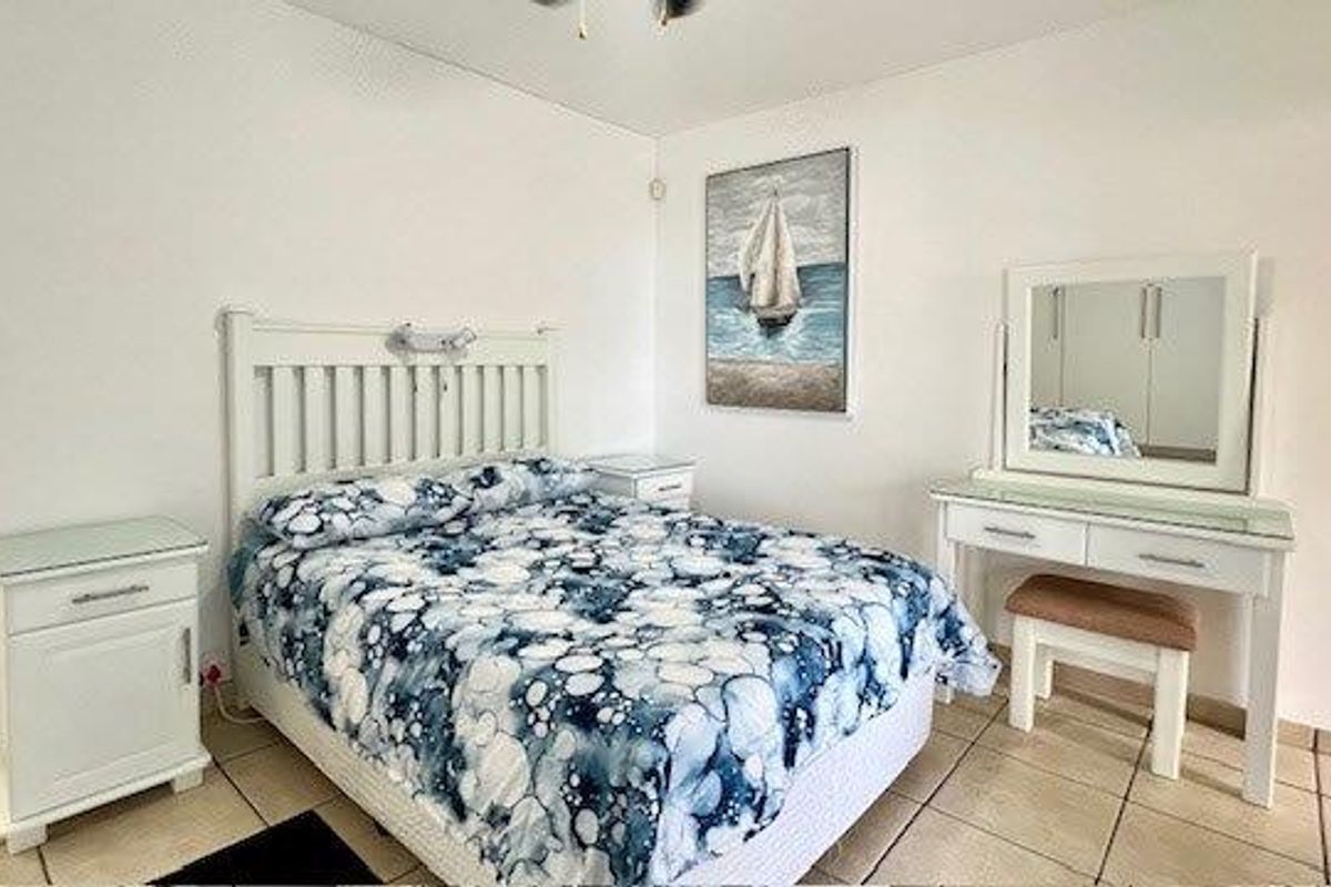 A functional bedroom featuring tiled flooring and a ceiling fan, providing a neutral space ready for personalization.