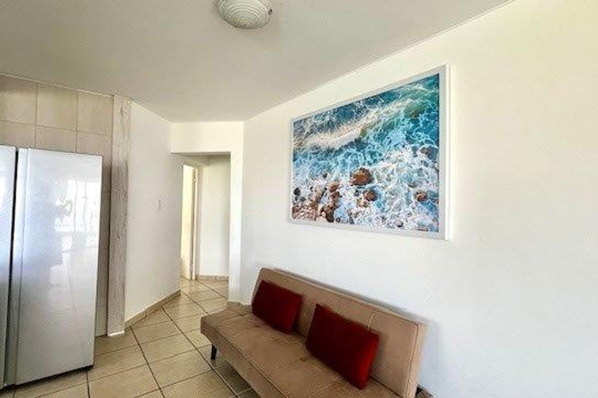 A functional living area featuring ceramic floor tiles and neutral wall finishes, providing a clean and simple space.