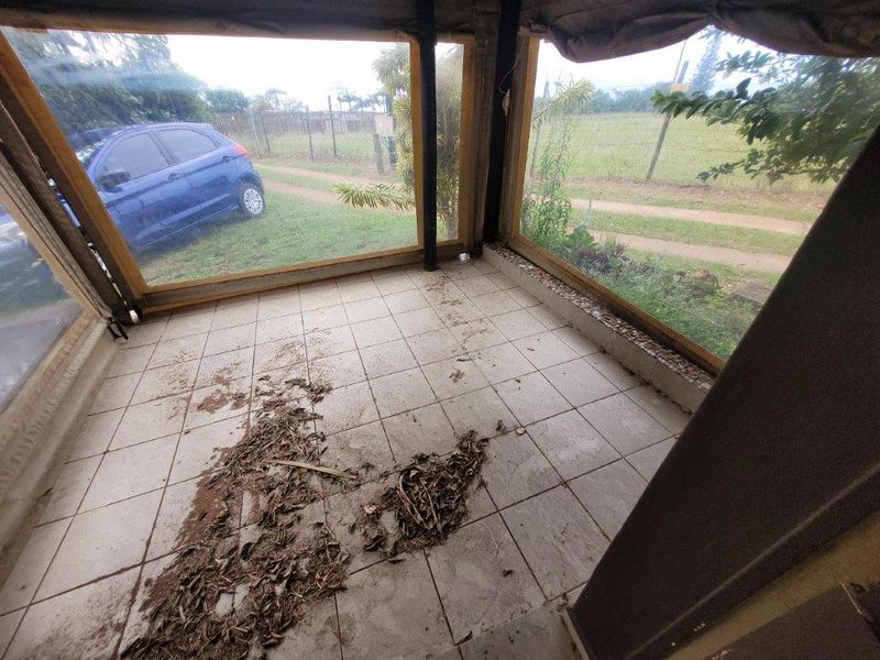 An enclosed patio area featuring tiled flooring and clear weather screens, currently requiring maintenance and cleaning to restore its outdoor living potential.