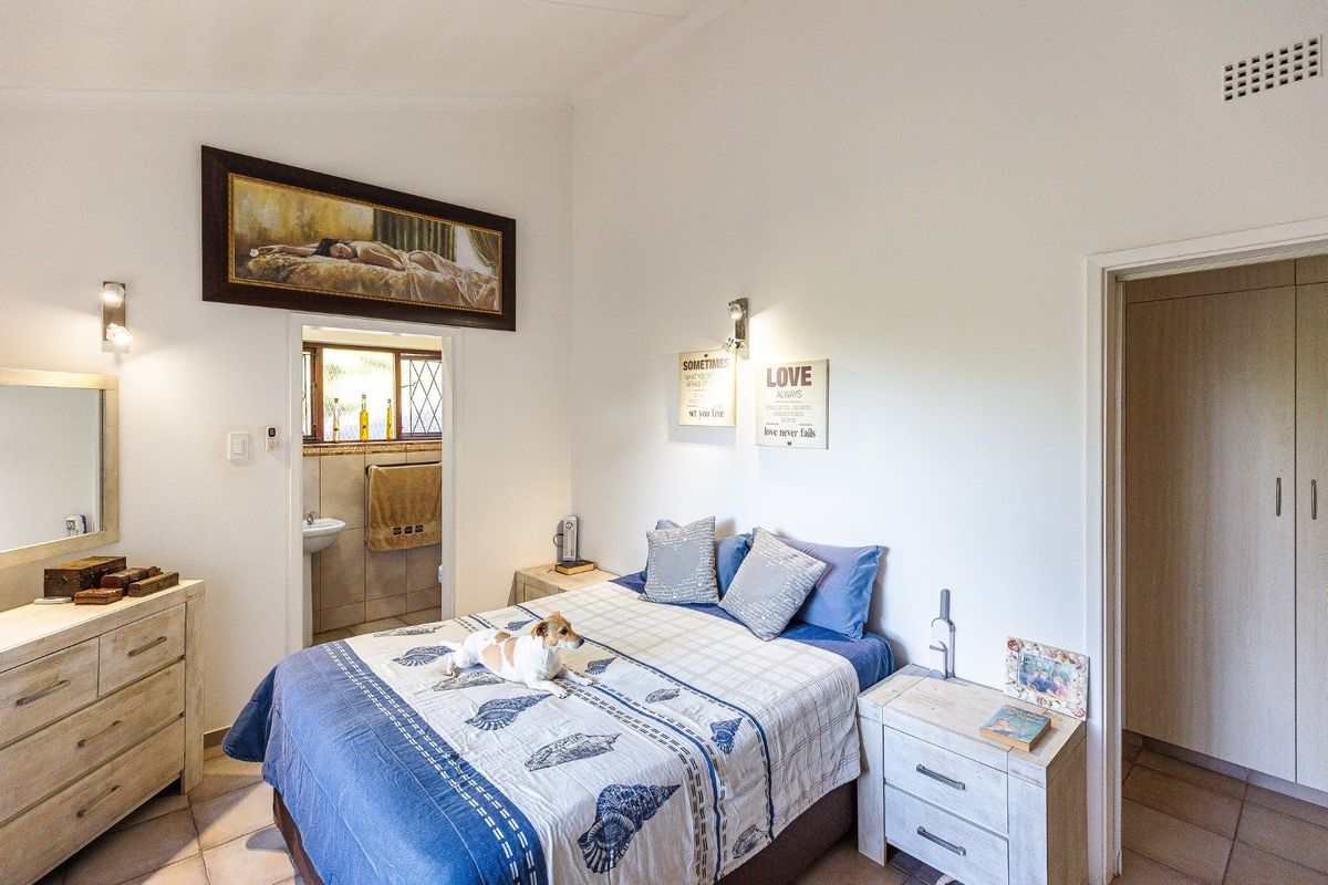 A bedroom featuring tiled flooring, built-in cupboards, and an en-suite bathroom access.