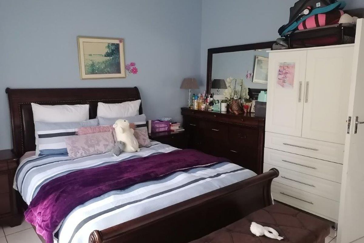 A standard bedroom featuring tiled flooring and neutral wall paint, providing a functional and comfortable living space.