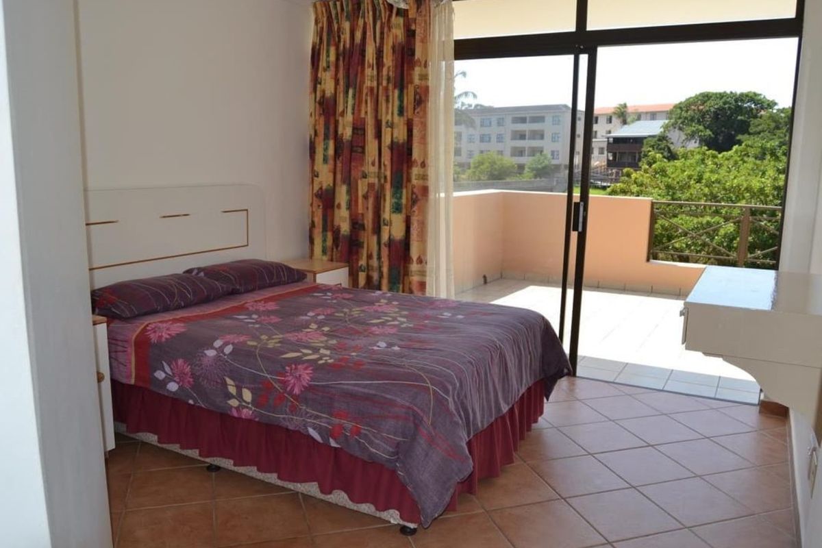 Bedroom featuring tiled flooring and a sliding glass door providing direct access to a private balcony with exterior views.