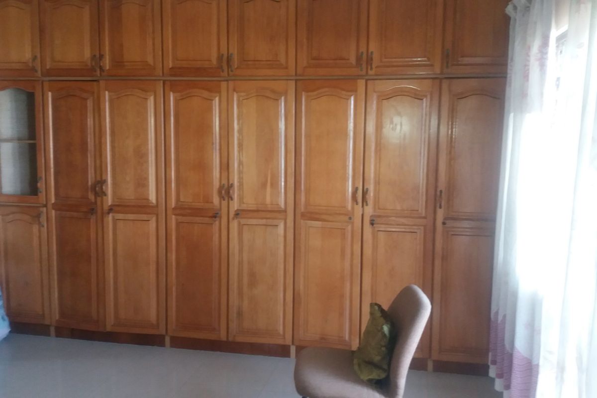 A bedroom featuring extensive floor-to-ceiling built-in wooden cabinetry providing ample storage space.